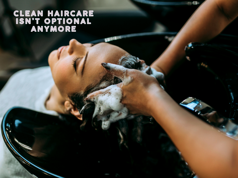 A stylist gently washing a client's hair with foaming shampoo, promoting clean beauty as a must-have salon standard.
