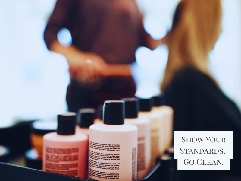 Stylist prepares to work while clean, clearly labeled bottles sit in the foreground, promoting salon quality.