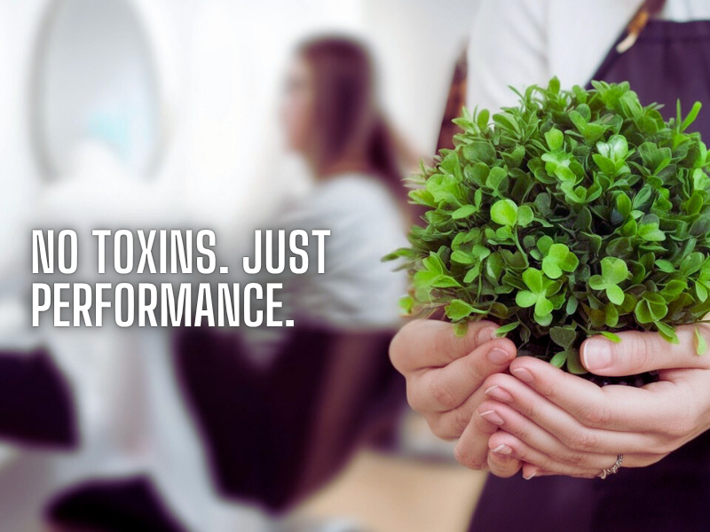 Salon professional holding green plant, symbolizing non-toxic, high-performance clean haircare in eco-conscious salons
