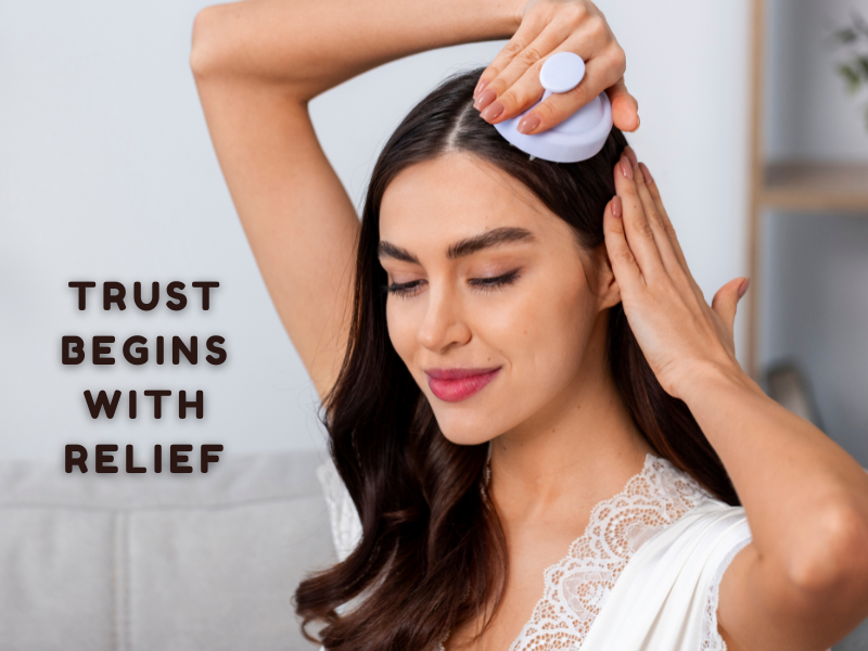 Woman massaging scalp with handheld tool while smiling—promotes natural scalp care, soothing relief, and client trust in clean beauty routines.